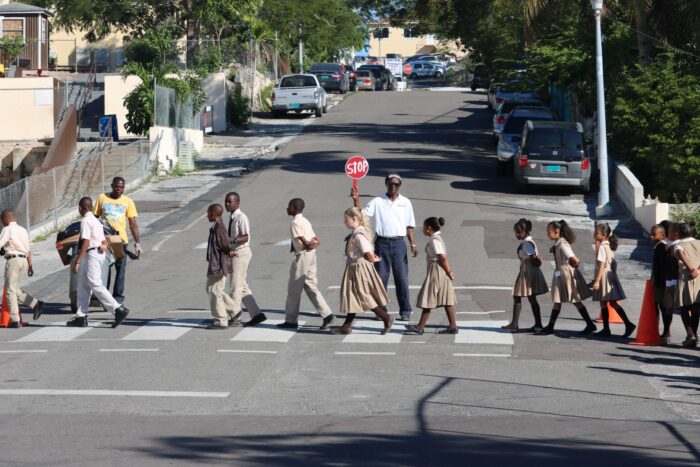 Elementary Students walking safely across street with crossing guard.